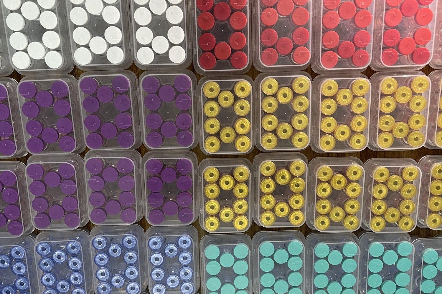 Straightened rows of peptide vial trays with multiple cap colors