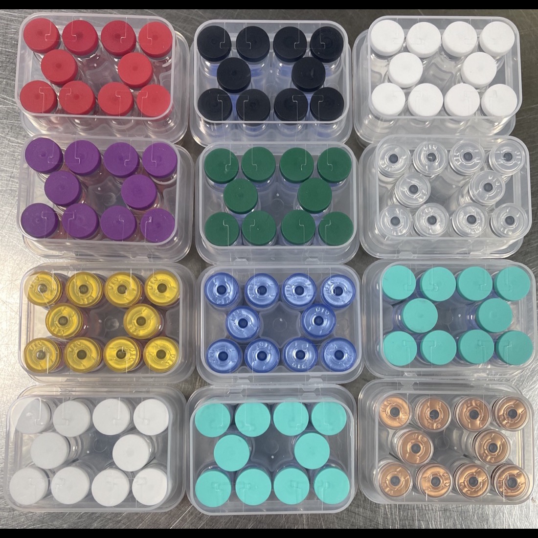A top-down display of peptide vial trays with multiple cap colors